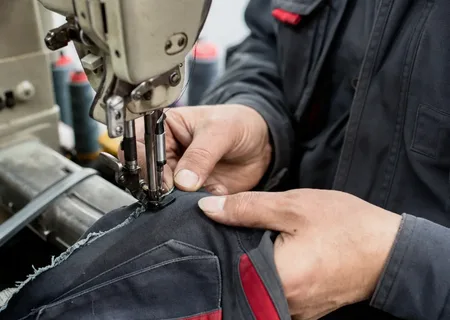 Reparatur einer Arbeitshose an der Nähmaschine