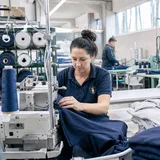 Näherin in der Produktion von Unternehmensbekleidung