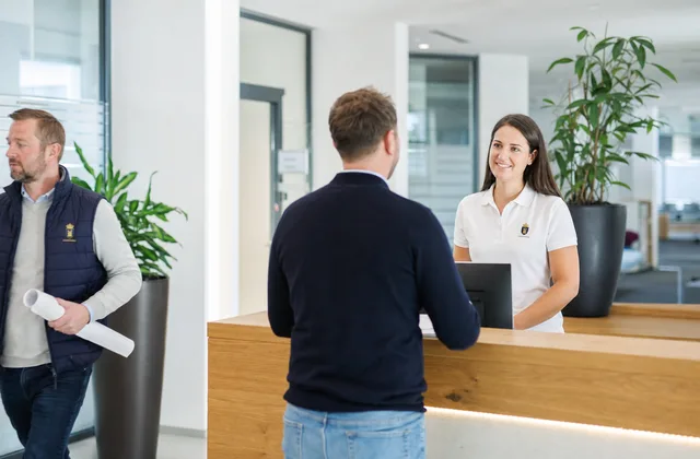 Empfang eines Unternehmens, Mitarbeiterin im weißen Polo mit gesticktem Logo