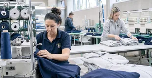 Produktion von Unternehmensbekleidung an der Nähmaschine