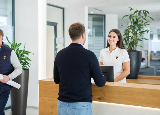 Mitarbeiter am Empfang in einheitlicher Unternehmensbekleidung